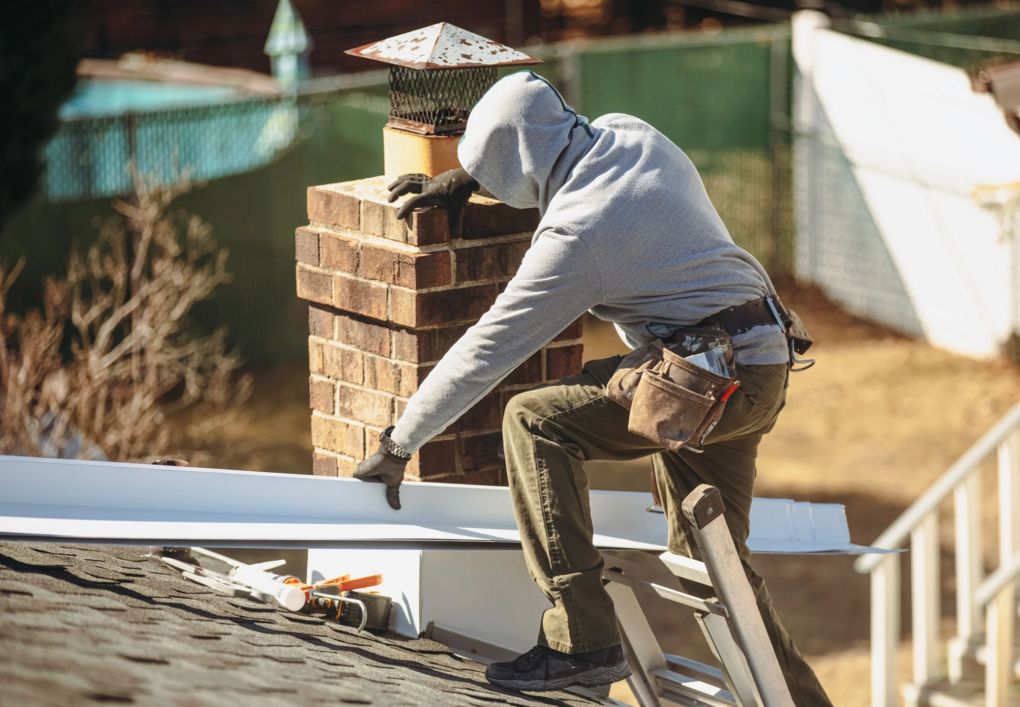 A professional roofer inspecting ridge capping on a northern suburbs home.